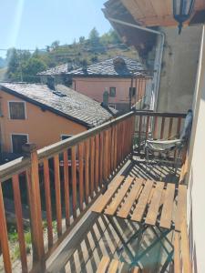 un balcón con un banco de madera y una casa en Au Coeur de Saint Nicolas, en Saint Nicolas