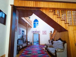 una sala de estar con escalera y una habitación con alfombra en Khiva Siyovush Hotel en Khiva
