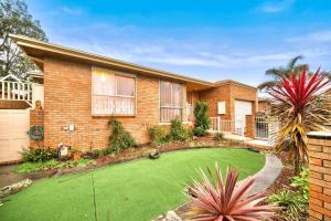 a house with a green lawn in front of it at Charming 3BR Family Home In A Perfect Location in Narre Warren