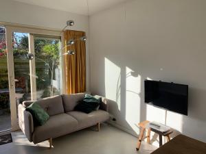 ein Wohnzimmer mit einem Sofa und einem Flachbild-TV in der Unterkunft The Corner in Bergen