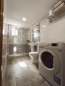 Un baño con inodoro y lavadora. en Apto céntrico INDUSTRIAS VUT 47-215, en Valladolid
