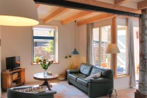 een woonkamer met een bank en een tv bij de Dars in Callantsoog