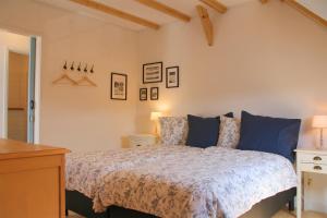 een slaapkamer met een bed met blauwe kussens bij de Dars in Callantsoog