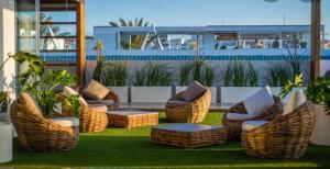 a group of wicker chairs and tables on a patio at Elegant apartment next to the sea! in Corralejo