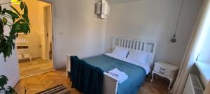 - une chambre avec un lit doté d'une couverture bleue dans l'établissement Ioana Apartment Resita, à Reşiţa