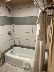 a white bath tub in a bathroom with a shower at Hotel Weston RFD in Rockford