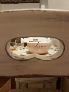einen Teller mit einer Schüssel und Gläsern auf dem Tisch in der Unterkunft A casa di Samuele in Squille