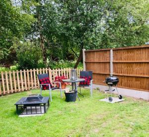 a backyard with a grill and chairs and a table at Green Little Acre in Little Singleton