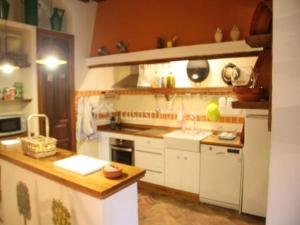 cocina con armarios blancos y encimera en El BALCÓN de los OLIVOS en Luque