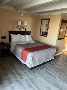 1 dormitorio con 1 cama grande y espejo en Hotel Weston RFD, en Rockford