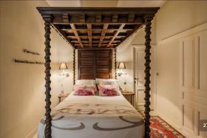 Luxury Villa in front of the famous Pont-du-Gard. في كاستيون-دو-غارد: غرفة نوم مع سرير المظلة مع الوسائد الزهرية