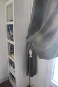 a coat hanging from a wall next to a book shelf at Chambre au panier in Marseille