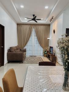De Jara Guesthouse Dungun for Malay في دونجون: غرفة معيشة مع طاولة ومروحة سقف