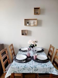 a dining room table with plates and flowers on it at ALIZE in Reda