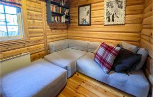 a small room with a couch in a log cabin at Amazing Home In Fvang With Wifi And 7 Bedrooms in Favang