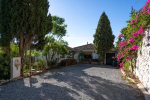 een oprit voor een huis met bloemen bij Back to La Tierra, natural finca in Mijas in Mijas