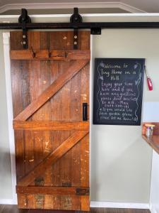 eine Scheunentür mit einer Tafel an der Wand in der Unterkunft Tiny Home on a Hill in Heathcote