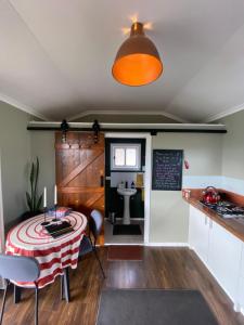 a room with a table and a kitchen with a sink at Tiny Home on a Hill in Heathcote