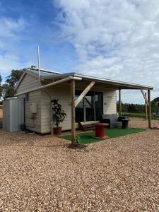a small white house with a roof at Tiny Home on a Hill in Heathcote
