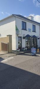 a white building with a sign in front of it at The Ferry Boat in Portmagee