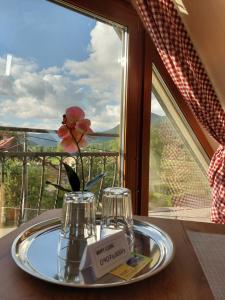 einen Teller mit einer Blume auf einem Tisch vor einem Fenster in der Unterkunft Privat LeNa in Ružomberok