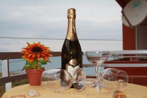 a bottle of wine sitting on a table with glasses at GB Case Vacanze Sicilia in Balestrate