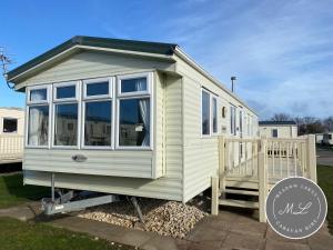 ein winziges Haus mit großem Fenster auf viel in der Unterkunft Coral Beach - Ingoldmells - Row 89 Van 1 in Ingoldmells