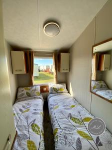 una piccola camera con due letti e una finestra di Coral Beach - Ingoldmells - Row 89 Van 1 a Ingoldmells