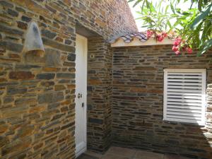 a brick wall with a door and a window at Tranquilos estudios cerca de la playa in Cadaqués