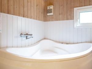 eine weiße Badewanne im Bad mit Fenster in der Unterkunft 6 person holiday home in Saltum in Saltum