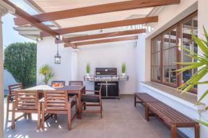 un patio con mesa, sillas y parrilla en Scandinavian Design Villa en Marbella