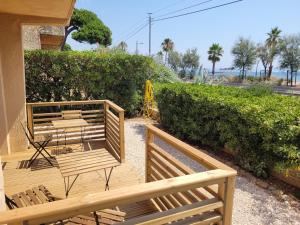two benches sitting next to a building with a hedge at T2 bord de mer - les embruns in Hyères