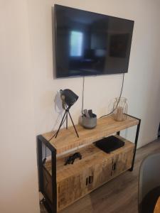 a flat screen tv on top of a wooden entertainment center at T2 bord de mer - les embruns in Hyères