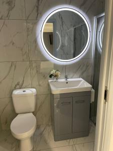 a bathroom with a toilet and a sink and a mirror at Hot tub hideaway in Manchester