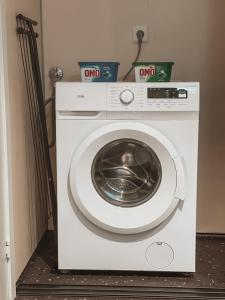 uma máquina de lavar roupa branca sentada num quarto em Unik liten leilighet i Stamsund, midt i Lofoten em Rishaugen