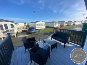 a deck with chairs and a table and houses at Butlins - Skegness in Ingoldmells