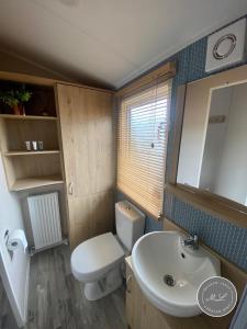 uma casa de banho com um WC branco e um lavatório. em Butlins - Skegness em Ingoldmells