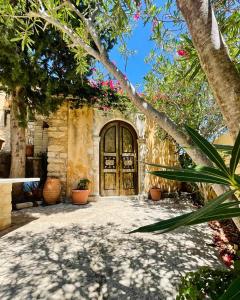 Una casa con una gran puerta con flores. en Monastiriako en Giannoudi