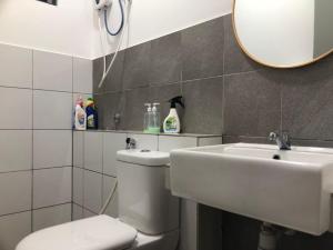 a bathroom with a toilet and a sink and a mirror at Sandakan Homestay Sea-Forest View Apartment 2R2B 海森雙景公寓 in Sandakan +32 photos