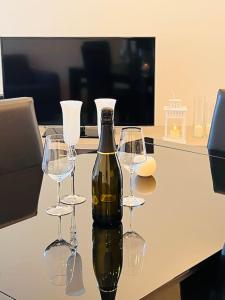 una botella de vino sentada en una mesa con cuatro copas de vino en Casa di Como., en Como