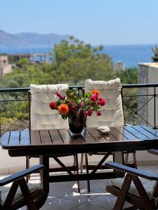 een tafel met een vaas met bloemen op een balkon bij Thedreamlifehouse in Anavissos