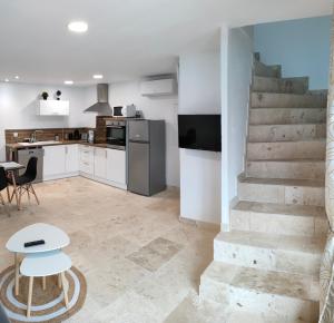 a kitchen with a staircase and a table and chairs at Appartement dans Mas Provencal in Arles