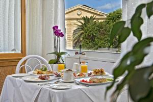 a table with plates of food on it with a window at Kydon The Heart City Hotel in Chania