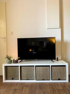 um centro de entretenimento branco com uma televisão de ecrã plano por cima em TOULOUSE - T2 moderne, quartier Lalande, 20min centre ville em Toulouse