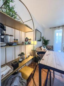 uma sala de estar com uma mesa e um quarto com um sofá em TOULOUSE - T2 moderne, quartier Lalande, 20min centre ville em Toulouse