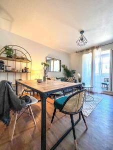 uma sala de estar com uma mesa de madeira e cadeiras em TOULOUSE - T2 moderne, quartier Lalande, 20min centre ville em Toulouse