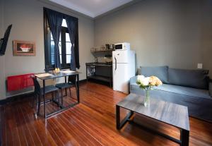 Una sala de estar con un sofá, una mesa y un refrigerador. en Maison Ramón, en Buenos Aires
