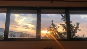 uma janela com vista para o pôr-do-sol em Thedreamlifehouse em Anavissos