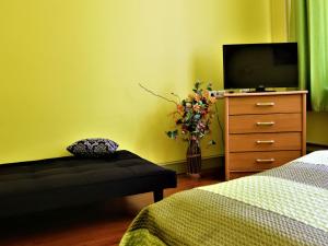 a bedroom with a bed and a dresser with a tv at Hostel Lõuna in Pärnu