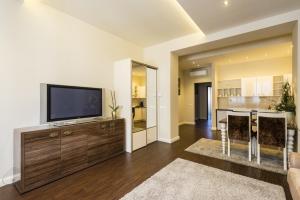 a living room with a flat screen tv on a wooden entertainment center at Hotel Ankavi in Szeged